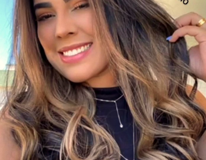 Retrato sorridente ao ar livre em luz quente — o rosto humano da representação ADLUX em Fortaleza.