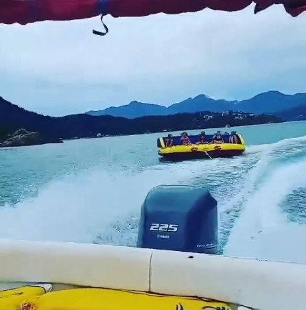 Grupo se divertindo em boia rebocada durante passeio de lancha compartilhado no Litoral Norte