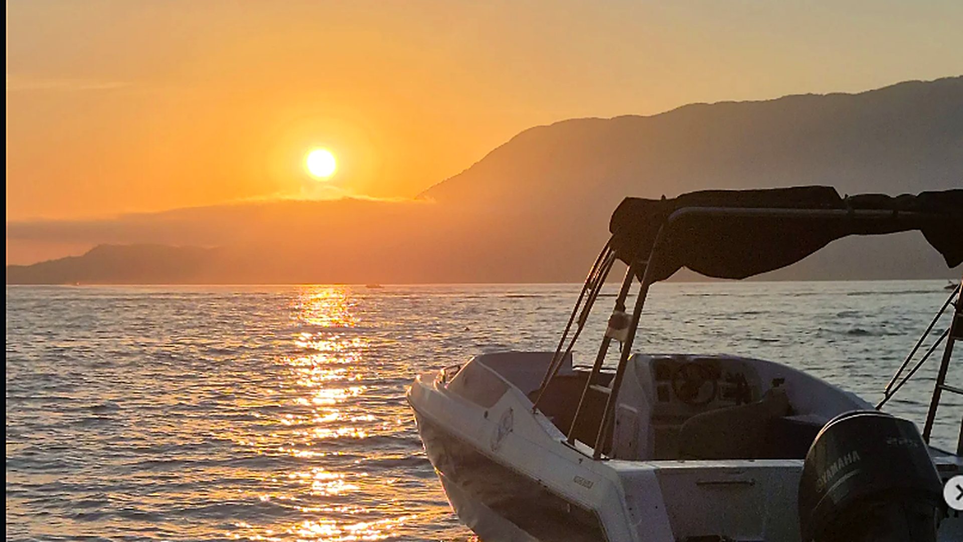 Lancha da AGEBOATTUR ao pôr do sol no mar de Ilhabela, Litoral Norte de São Paulo