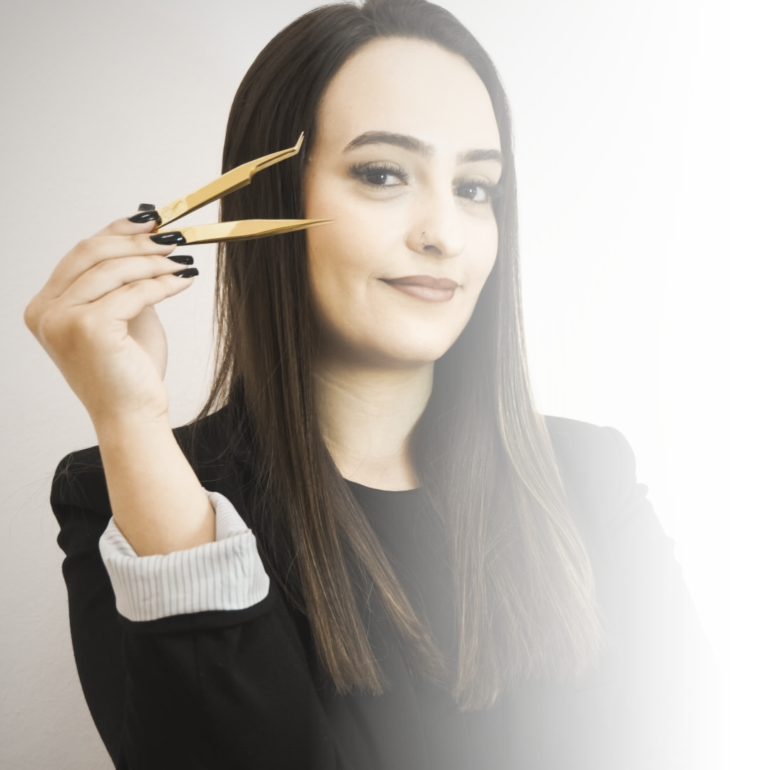 Carla Prado, especialista em design do olhar, segurando pinça dourada